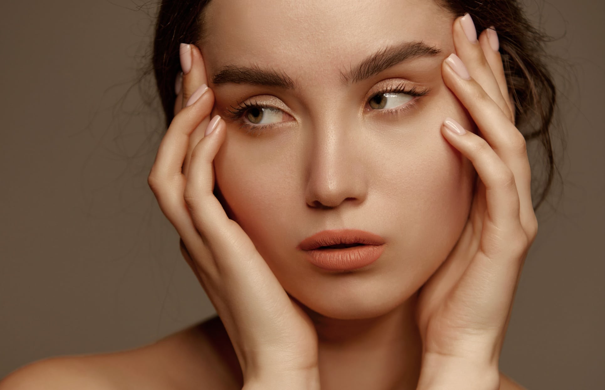 Photo stylisee du visage d une jeune femme qui pose sa main sur les coin des yeux lifting temporal | Dr Christophe Reinbold Lyon